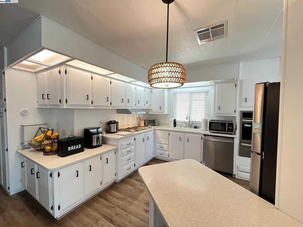 711 Old Canyon Road Fremont, CA 94536 - Photo 9 of 29 a kitchen with stainless steel appliances granite countertop a sink a stove and refrigerator