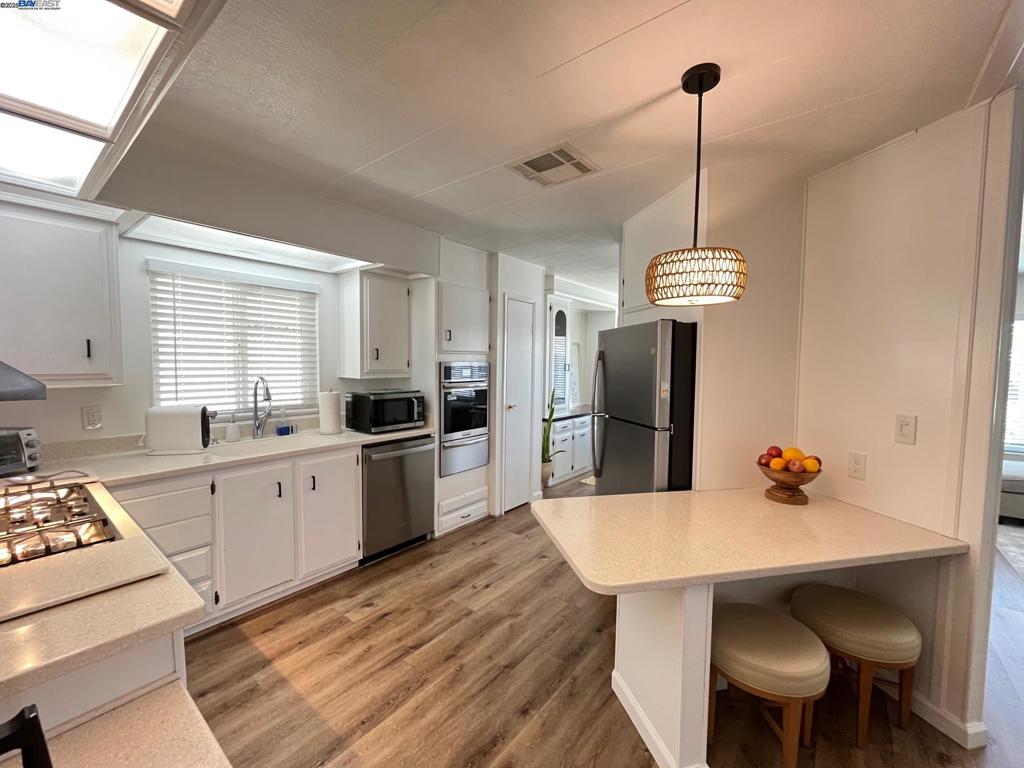 711 Old Canyon Road Fremont, CA 94536 - Photo 10 of 29 a kitchen with a dining table chairs and white appliances