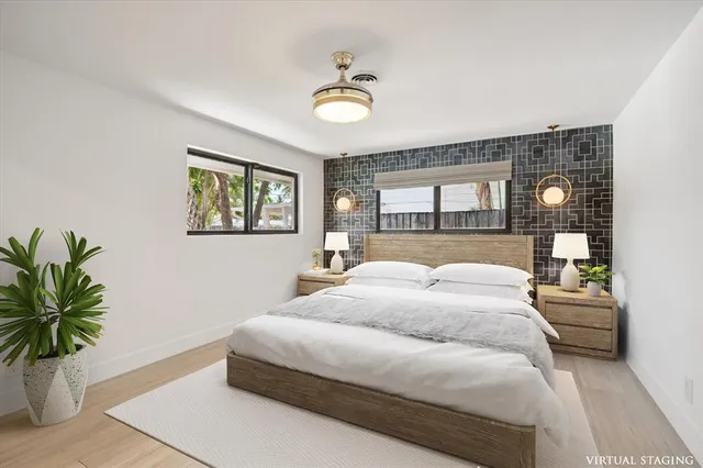 a bedroom with a large bed and a potted plant