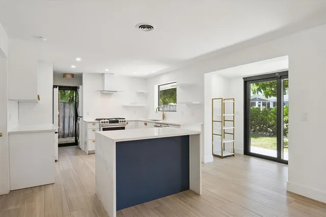 a kitchen with kitchen island a sink appliances and cabinets