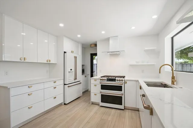 a kitchen with white cabinets and stainless steel appliances
