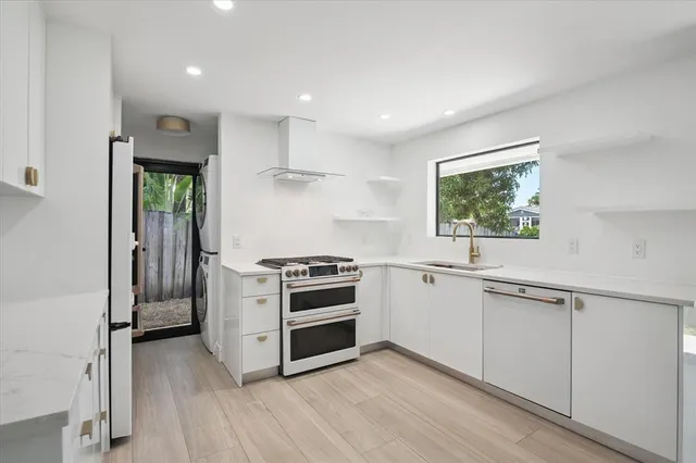 a kitchen with stainless steel appliances a stove a sink and a refrigerator