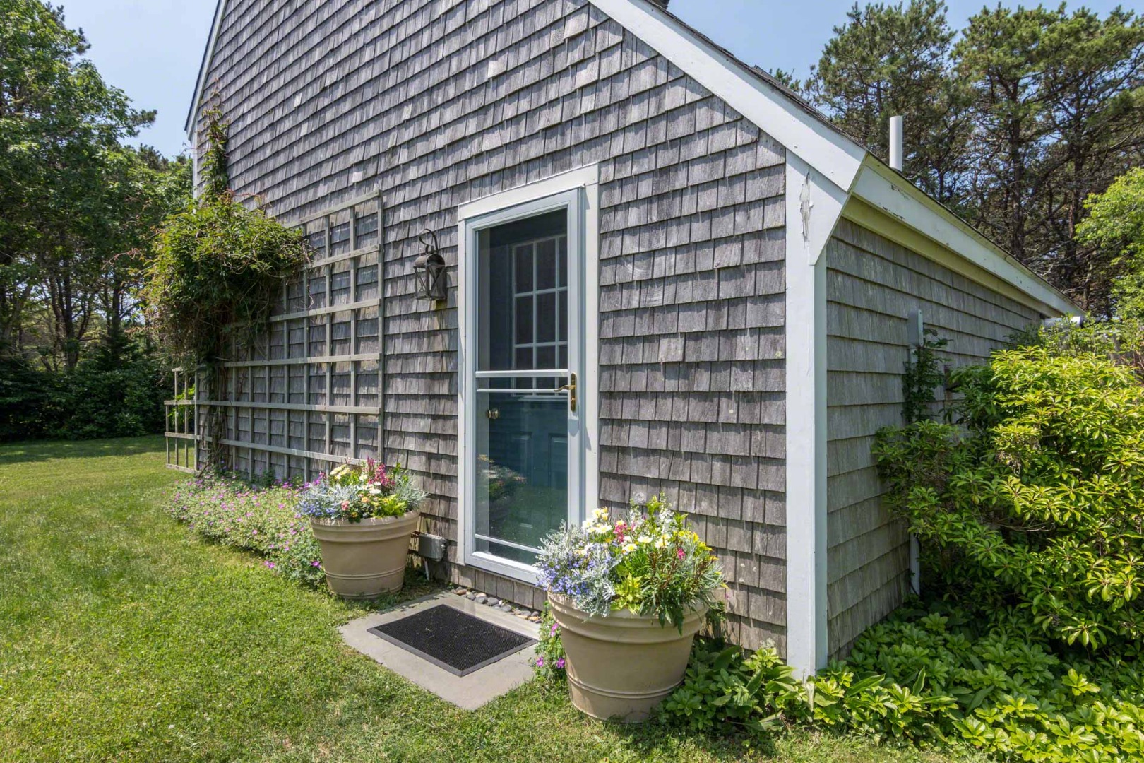 1 Garden Cove Road Edgartown, MA 02539 - Photo 36 of 37 a front view of a house with a yard and potted plants