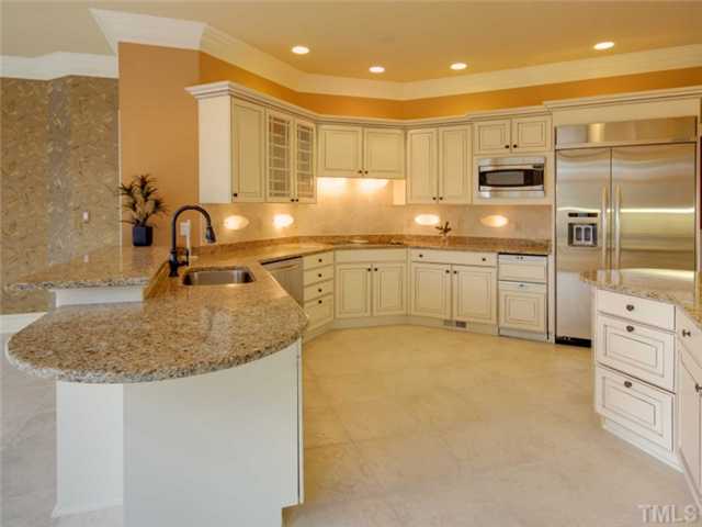 12140 Lockhart Lane Raleigh, NC 27614 - Photo 5 of 12 The remodeled kitchen is open to the family room. It offers granite counters, stainless appliancesthat include double ovens and a microwave, a NEW built in frig, and ivory-glazed cabinets.