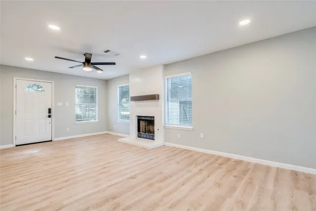 a view of empty room with wooden floor and fireplace