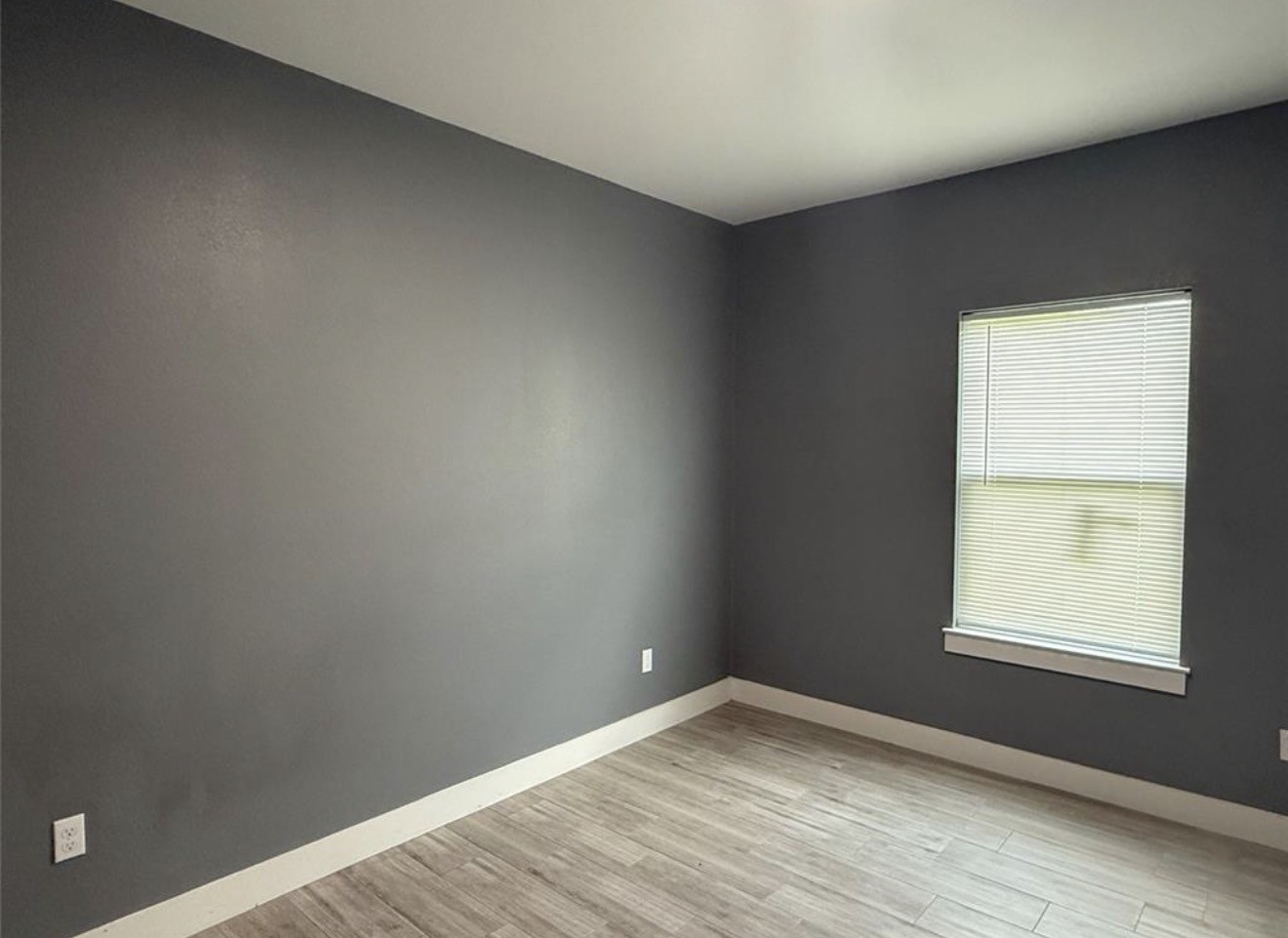 9815 Garcroft Street Houston, TX 77029 - Photo 11 of 14 an empty room with wooden floor and windows