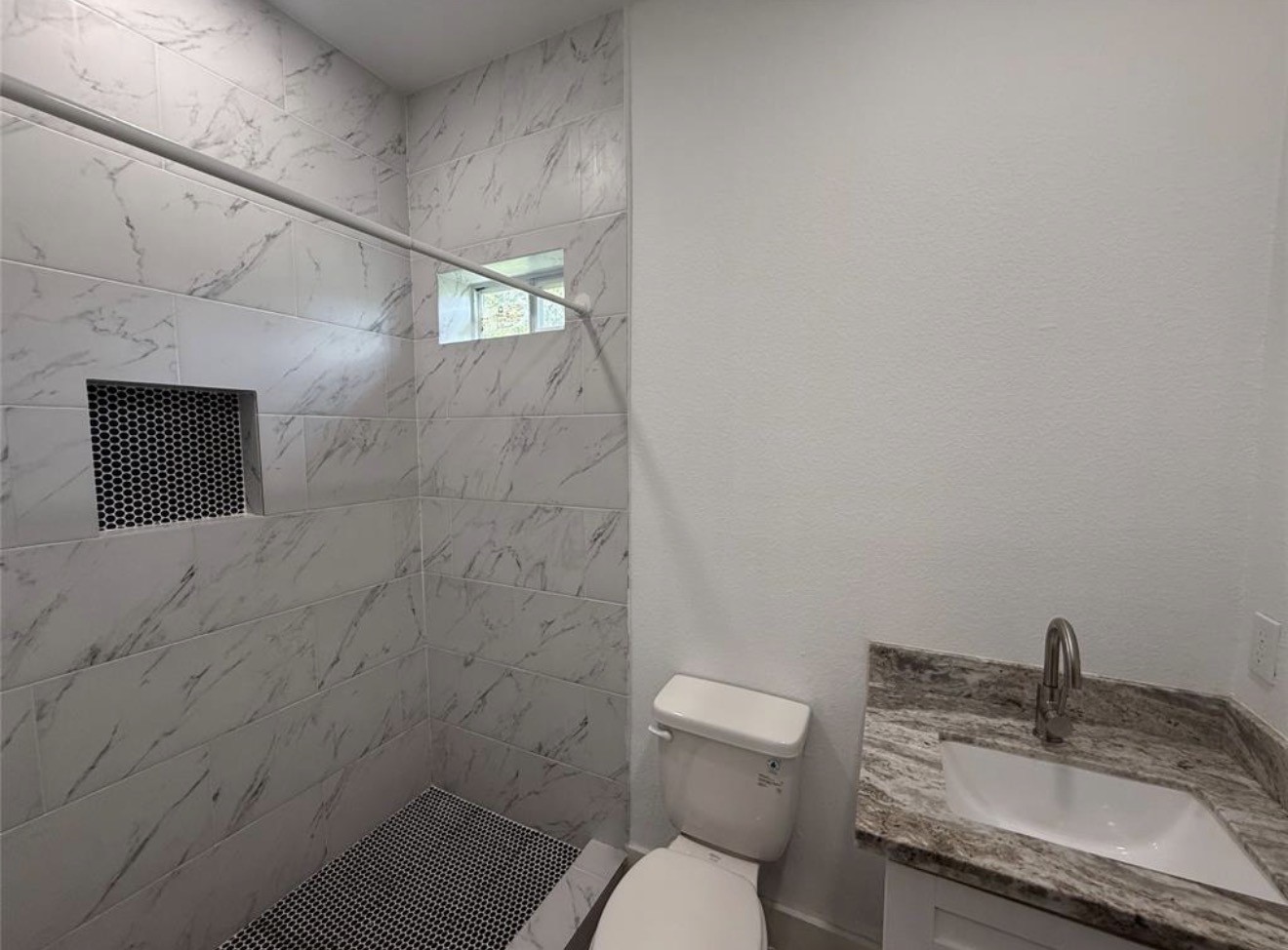 9815 Garcroft Street Houston, TX 77029 - Photo 14 of 14 a bathroom with a granite countertop sink toilet and shower