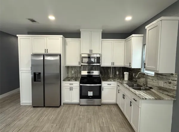 a kitchen with a refrigerator and a stove top oven