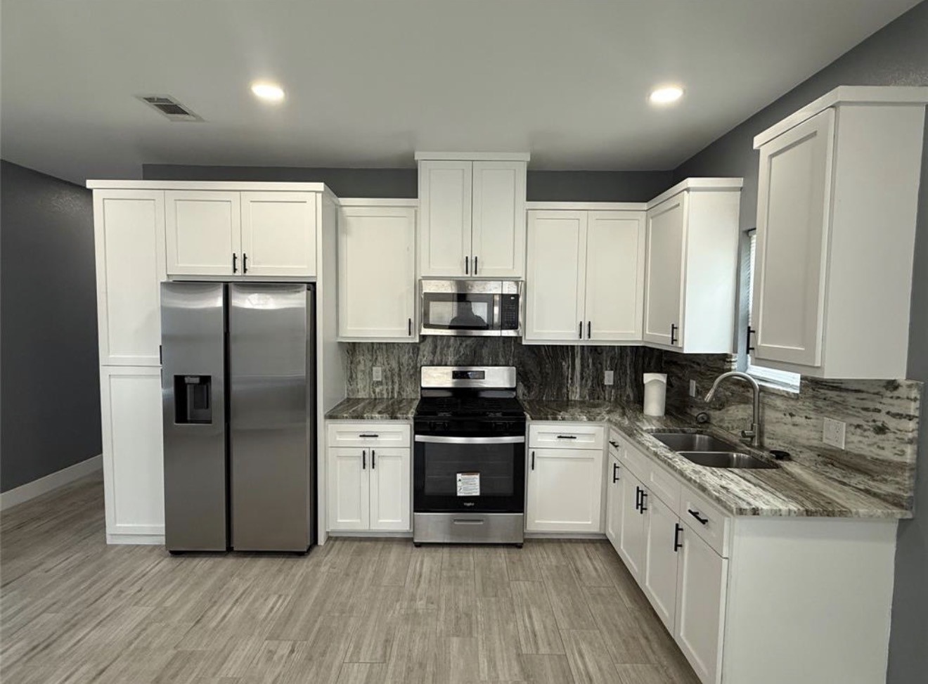 9815 Garcroft Street Houston, TX 77029 - Photo 4 of 14 a kitchen with a refrigerator and a stove top oven
