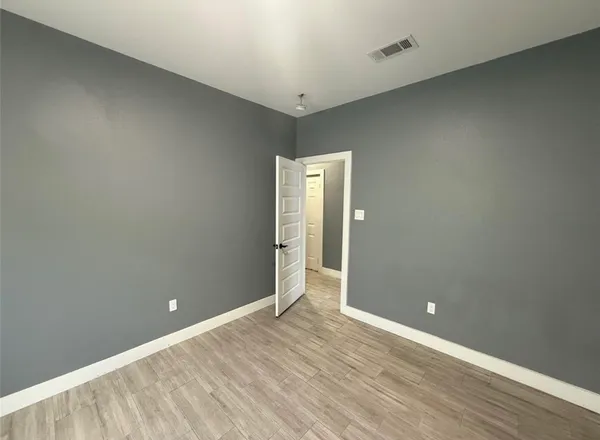 an empty room with wooden floor and sliding door