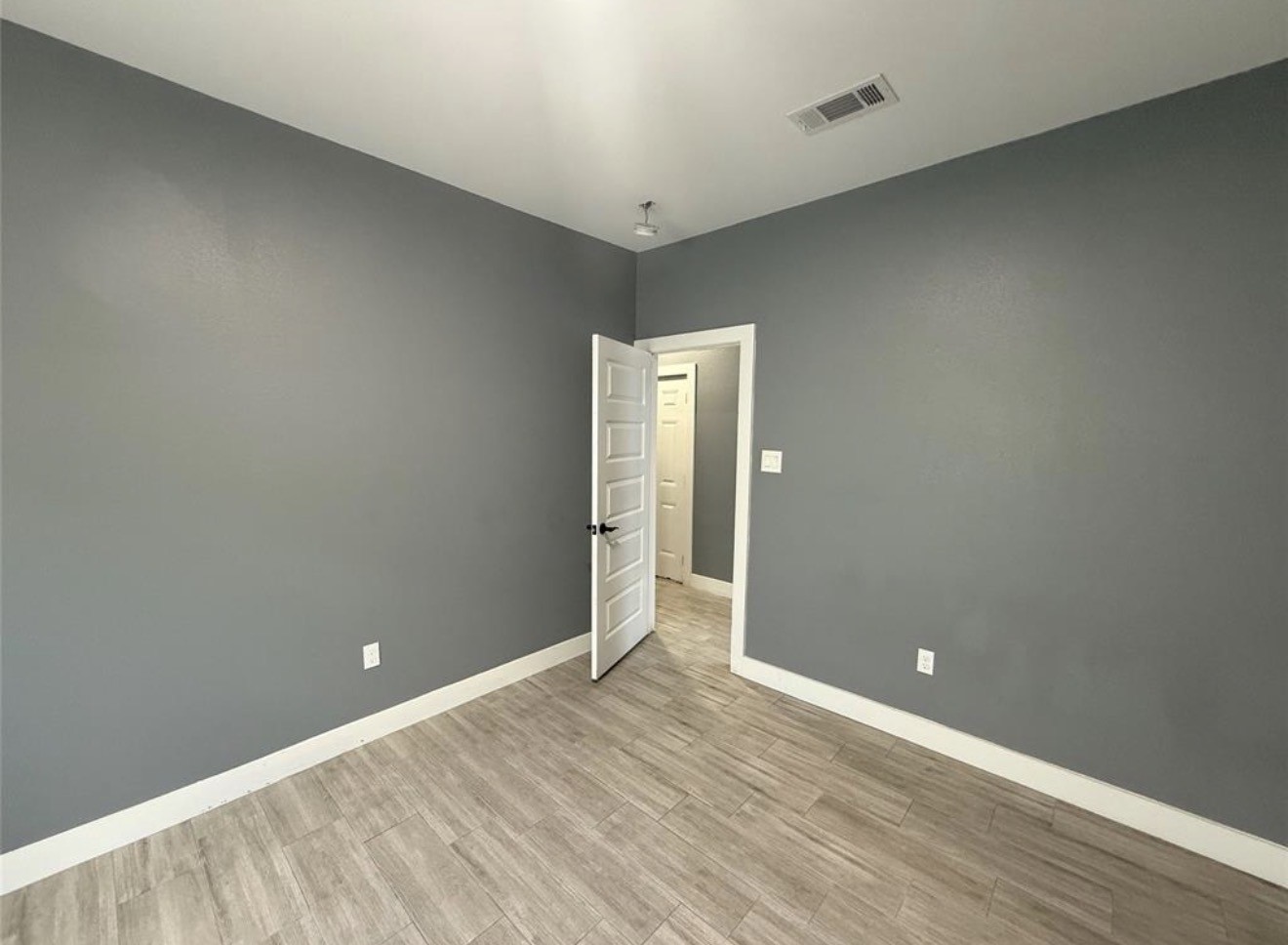 9815 Garcroft Street Houston, TX 77029 - Photo 10 of 14 an empty room with wooden floor and sliding door