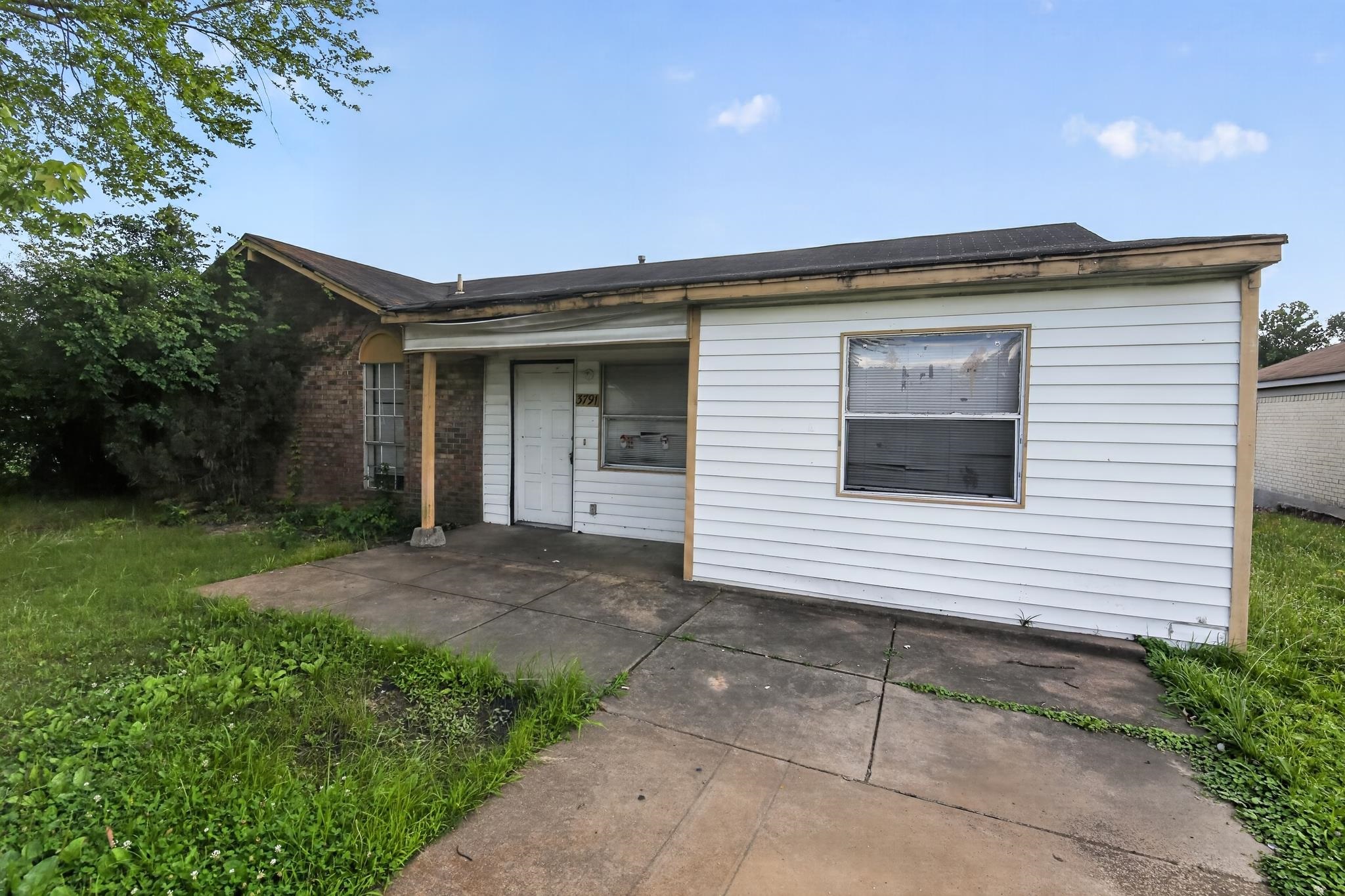 Brick and siding exterior featuring a covered porch