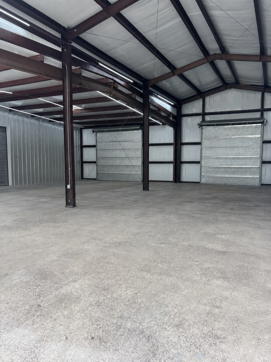 12126 Zion Road Tomball, TX 77375 - Photo 38 of 50 Thoughtfully designed with overhead doors at both the front and rear, this exceptional building captures natural cross-breezes, creating a cooler, more comfortable workspace even in the Texas heat.
