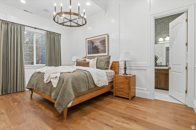 115 East Hidden Ridge Lane, Unit 42 Mapleton, UT 84664 - Photo 71 of 103 Bedroom featuring wood-finish flooring, white panel molding, and a contemporary chandelier