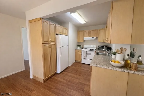a kitchen with a refrigerator sink and wooden cabinets