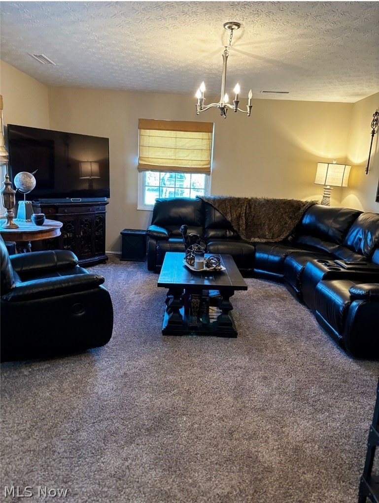 2514 Raber Road, Unit 4A Uniontown, OH 44685 - Photo 3 of 13 Living room featuring a notable chandelier, carpet, and a textured ceiling