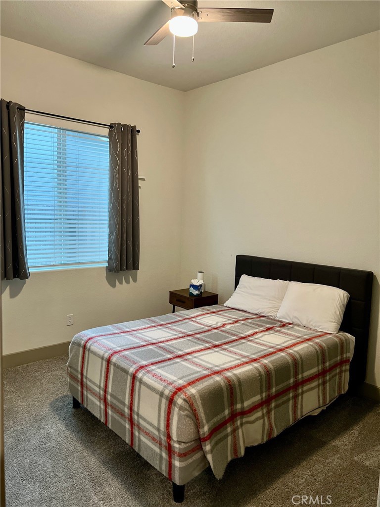 3751 Gabriel Drive Merced, CA 95340 - Photo 19 of 30 a bedroom with a bed lamp and a chandelier