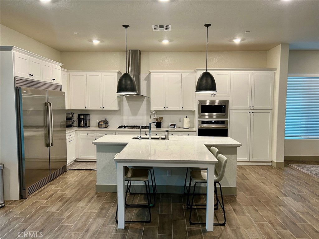 3751 Gabriel Drive Merced, CA 95340 - Photo 4 of 30 a white kitchen with a dining table chairs and wooden floor