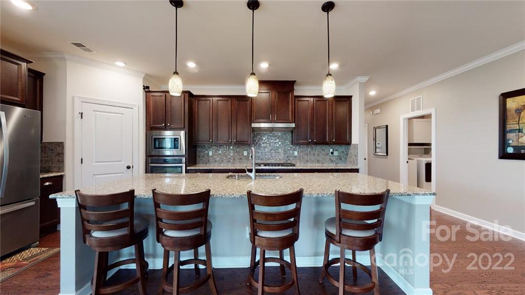 1137 Ellington Downs Way Monroe, NC 28110 - Photo 5 of 23 a large kitchen with a kitchen island wooden cabinets and stainless steel appliances