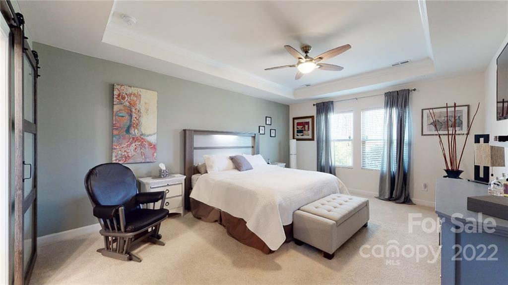 1137 Ellington Downs Way Monroe, NC 28110 - Photo 9 of 23 a bedroom with a large bed and a chandelier