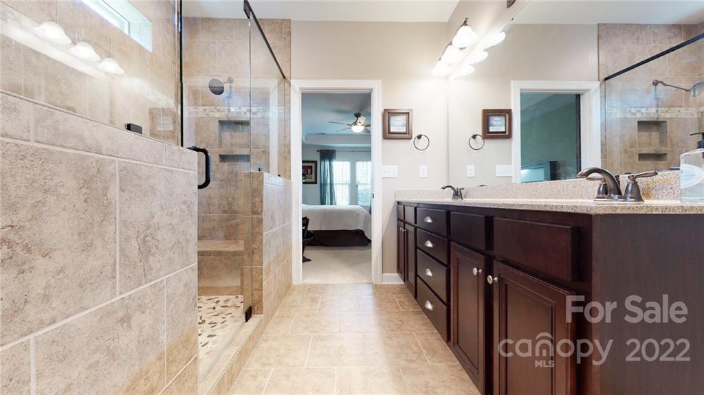 1137 Ellington Downs Way Monroe, NC 28110 - Photo 10 of 23 a en suite bathroom with a double vanity sink a toilet a mirror and shower