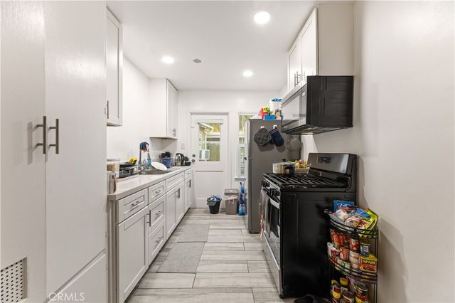 a kitchen with white cabinets and appliances