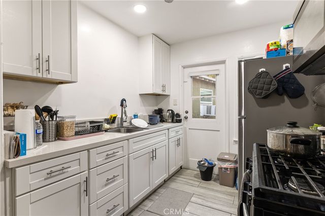 a kitchen with stainless steel appliances a sink stove and cabinets