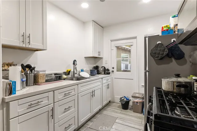 a kitchen with stainless steel appliances a sink stove and cabinets