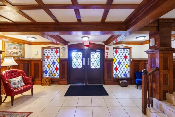 a view of an empty room with kitchen and a window