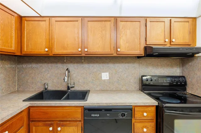 a kitchen with stainless steel appliances granite countertop a sink a stove and a microwave