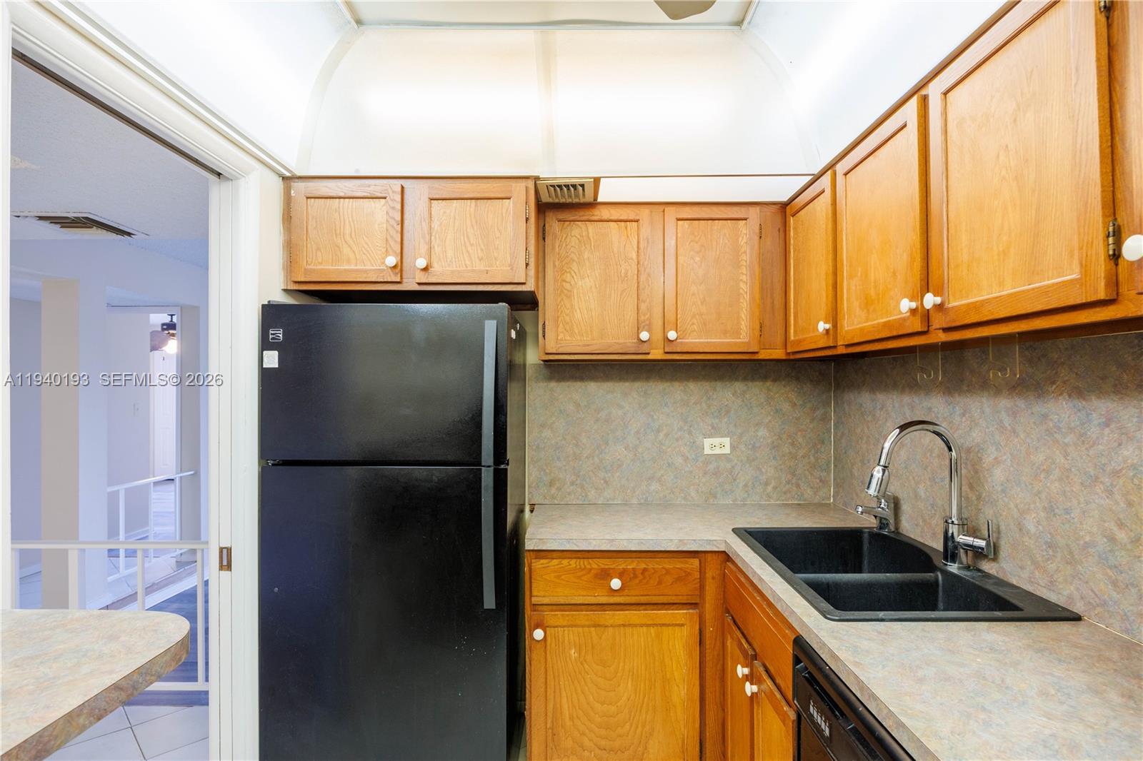 3760 Inverrary Drive, Unit 3D Lauderhill, FL 33319 - Photo 6 of 22 a kitchen with a sink a refrigerator and cabinets