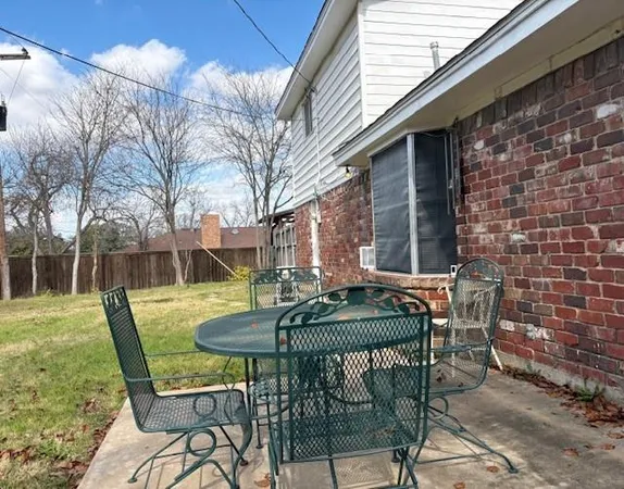 a view of a backyard with wooden fence