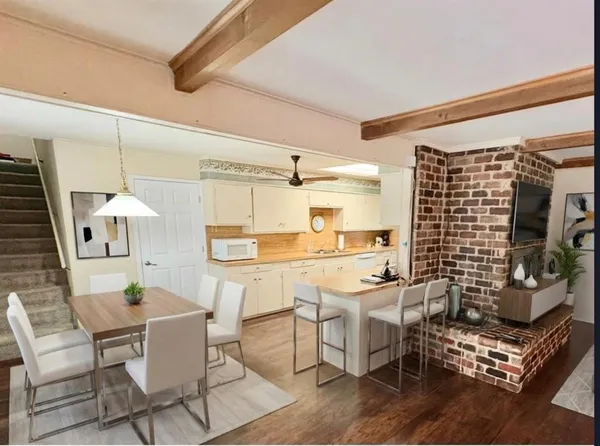 a room with stainless steel appliances kitchen island granite countertop a table and chairs in it