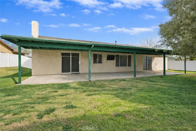 a backyard of a house with table and chairs