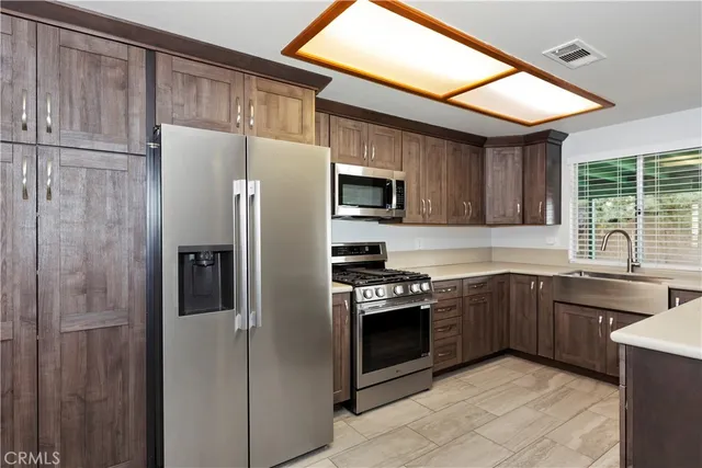 a kitchen with stainless steel appliances granite countertop a refrigerator stove a sink and dishwasher