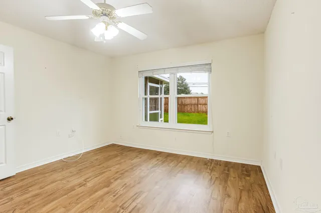 an empty room with a window and wooden floor