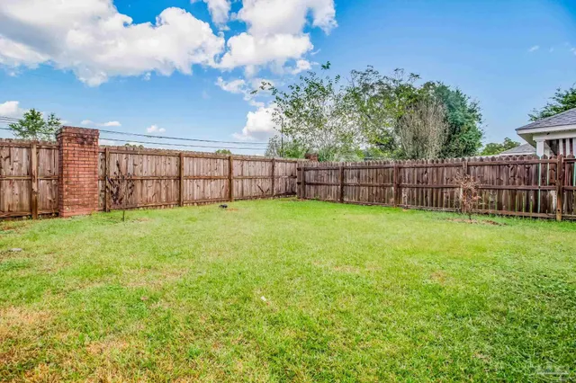 a view of a backyard with a garden and wooden fence