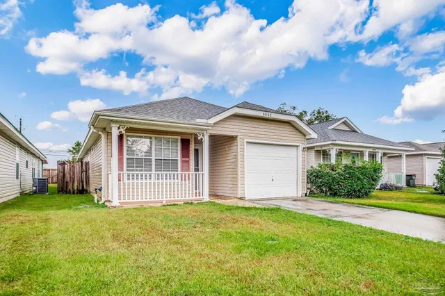 a view of a house with yard and large trees