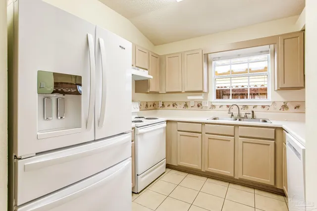 a kitchen with white cabinets and white appliances