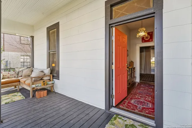 a view of a hallway with wooden floor and furniture