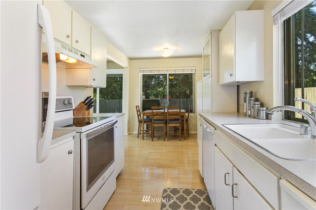 17322 24th Avenue Southeast Bothell, WA 98012 - Photo 11 of 24 a kitchen with stainless steel appliances granite countertop a sink and a refrigerator