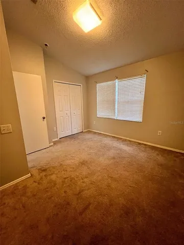 an empty room with closet and a bathroom