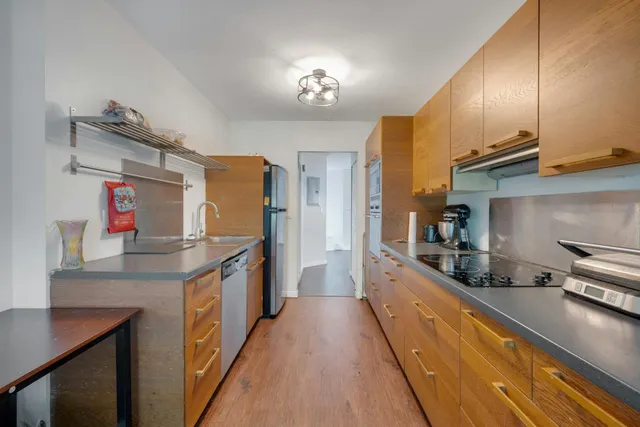 a kitchen with stainless steel appliances granite countertop a sink a stove and a refrigerator