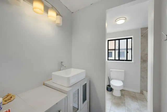 a bathroom with a toilet sink and mirror