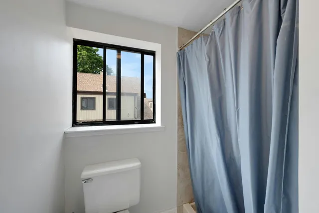 a bathroom with a window and a shower