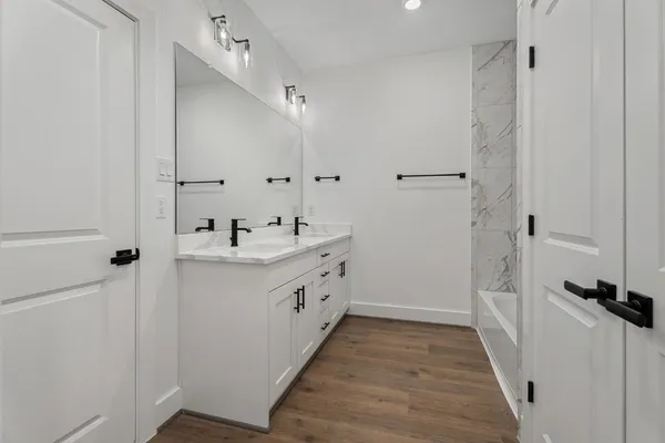 a bathroom with a tub a sink and a shower