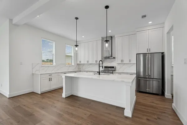a kitchen with stainless steel appliances granite countertop a stove a sink and a refrigerator