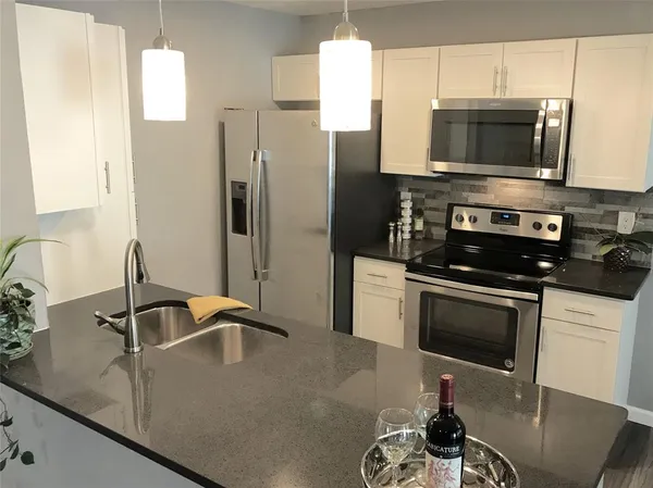 a view of a kitchen with wooden floor and a window
