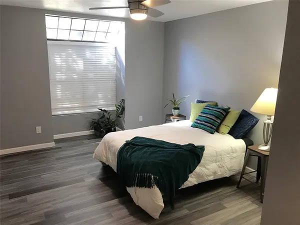 a spacious bedroom with a bed and a lamp