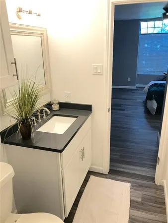 a bathroom with a granite countertop bathtub shower sink and toilet
